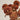 Dried orange flowers in a white vase against a plain background