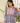 Woman wearing a blue and pink floral blouse with a blurred backgroud.